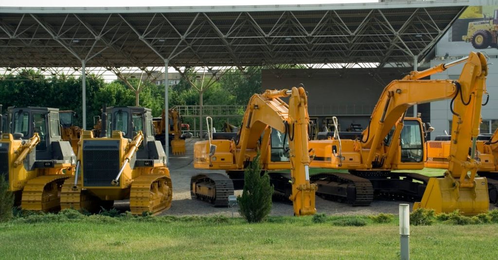 Heavy-duty construction machinery displayed outdoors, include excavators and bulldozers.